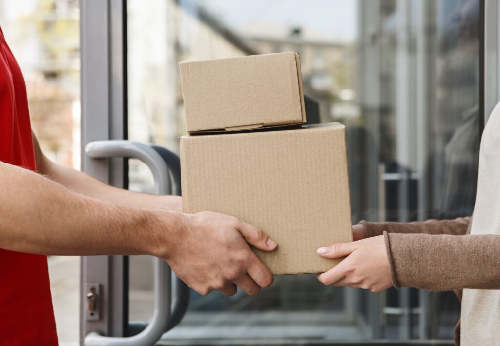 Guaranteed excellent service. Hands of client and courier are holding parcels